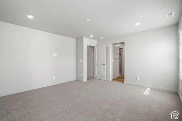 Neutral-toned carpeted flooring, recessed lighting, and solid-core interior doors