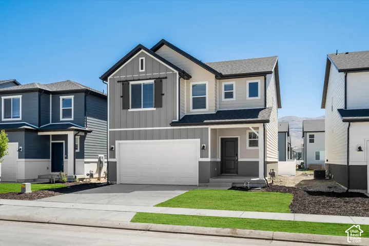 Two-story exterior featuring a mix of horizontal siding and vertical board-and-batten siding, a two-car garage, decorative exterior shutters, and a covered front entryway