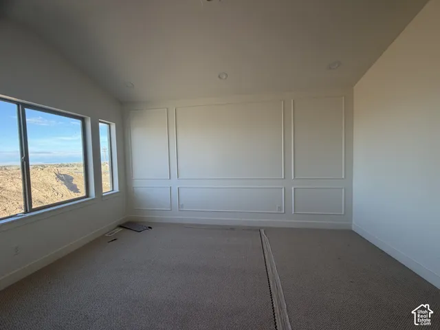Interior space featuring tall ceiling, picture frame wall molding, carpeting, and dual-pane windows with horizontal sliders