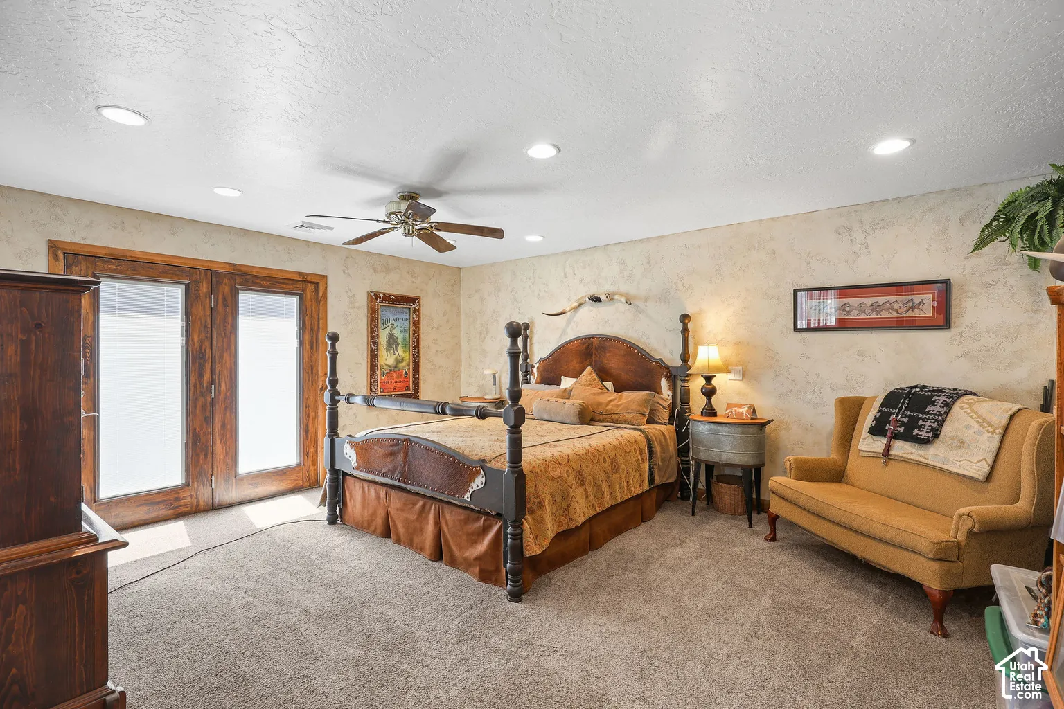 Textured wall finishes, recessed lighting, ceiling fan, and wooden French doors