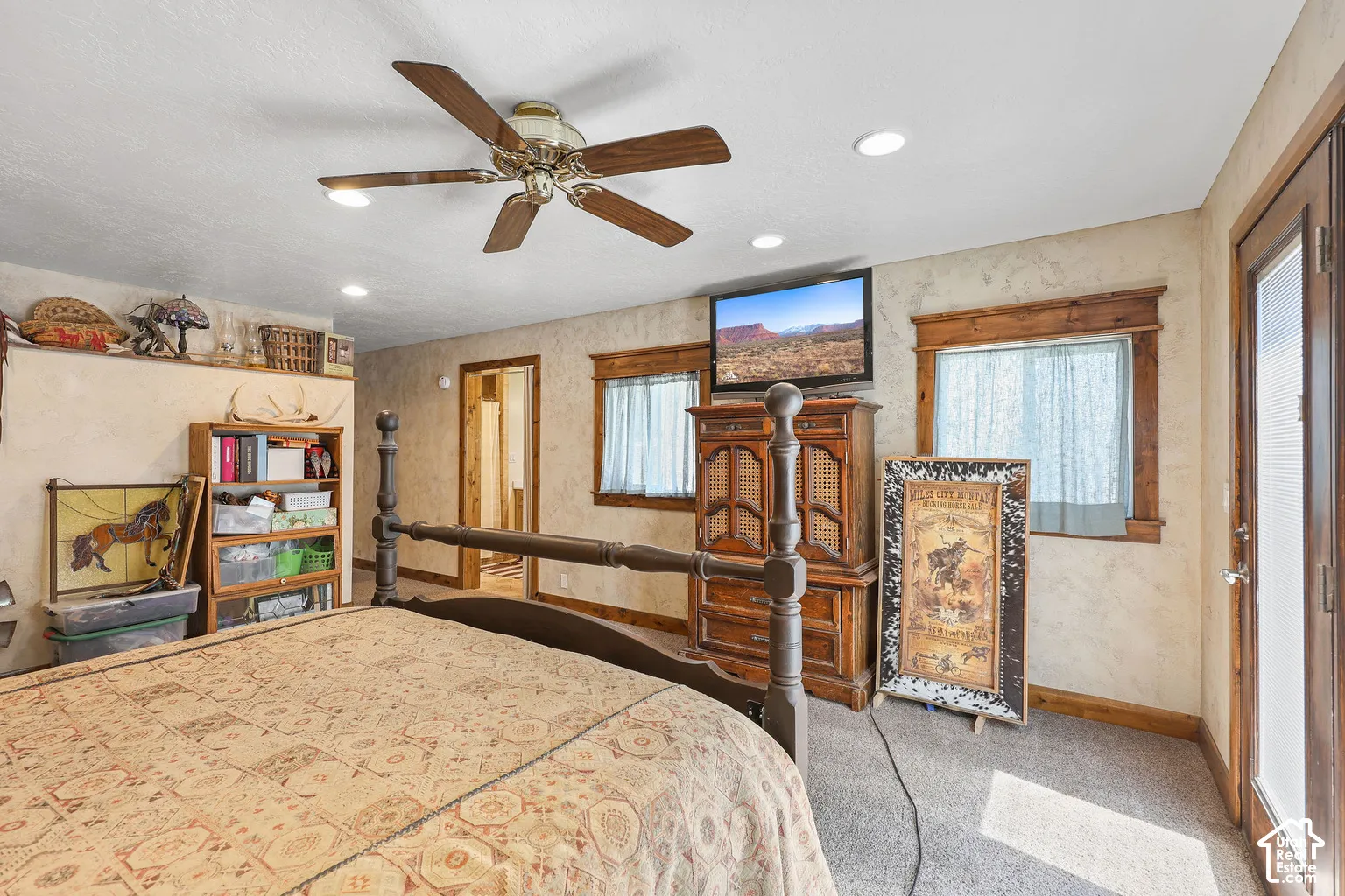 Interior space featuring textured wall finishes, recessed lighting, a ceiling fan, wood-trimmed windows, and a glass-paneled exterior door