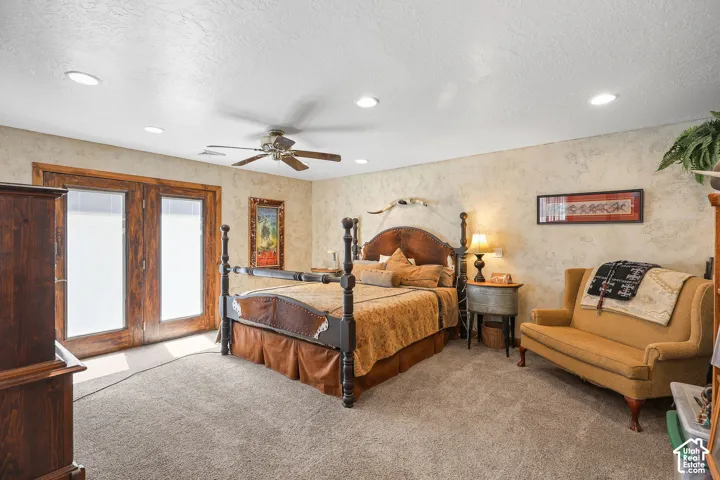 Textured wall finishes, recessed lighting, ceiling fan, and wooden French doors