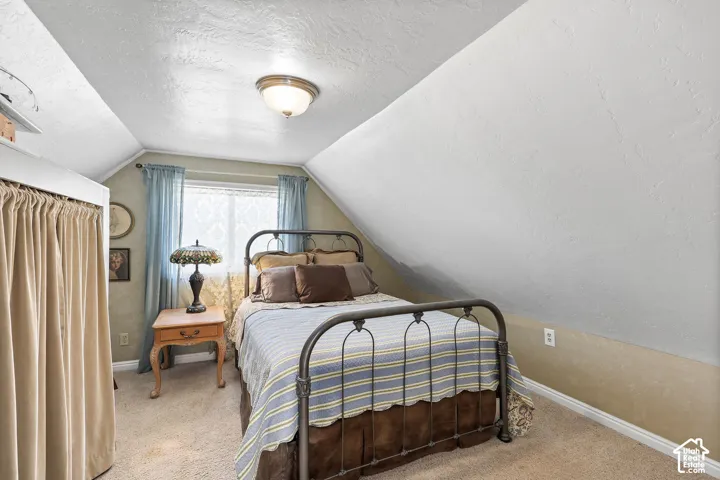 Angled ceilings, wall-to-wall carpeting, and a flush-mount ceiling light fixture
