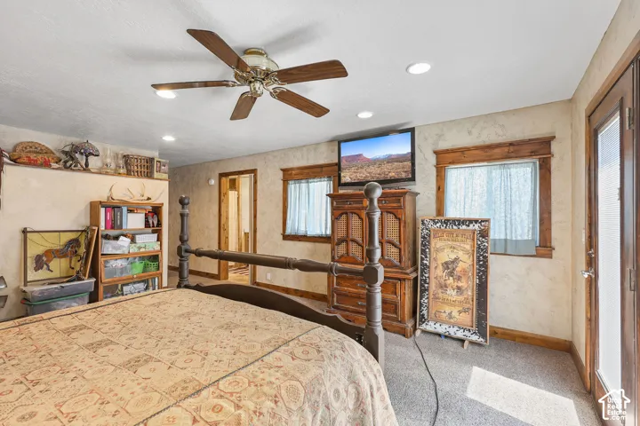 Interior space featuring textured wall finishes, recessed lighting, a ceiling fan, wood-trimmed windows, and a glass-paneled exterior door