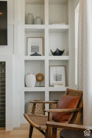 Built-in floor-to-ceiling shelving with white finish, integrated dark tile fireplace surround, and wood-finish flooring