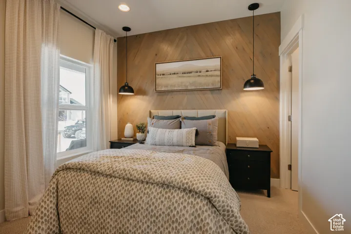 Interior space featuring a herringbone-patterned wood accent wall, dual matte black pendant light fixtures, and recessed ceiling lighting