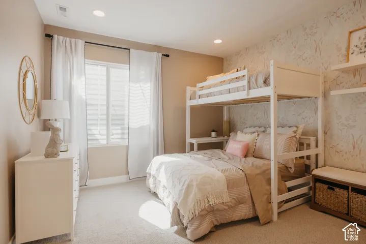 Neutral wall tones paired with patterned accent wallpaper, recessed lighting, and built-in floating wall shelving