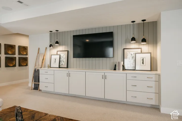 Built-in white cabinetry with multi-drawer storage, vertical shiplap accent wall, and dual pendant lighting fixtures