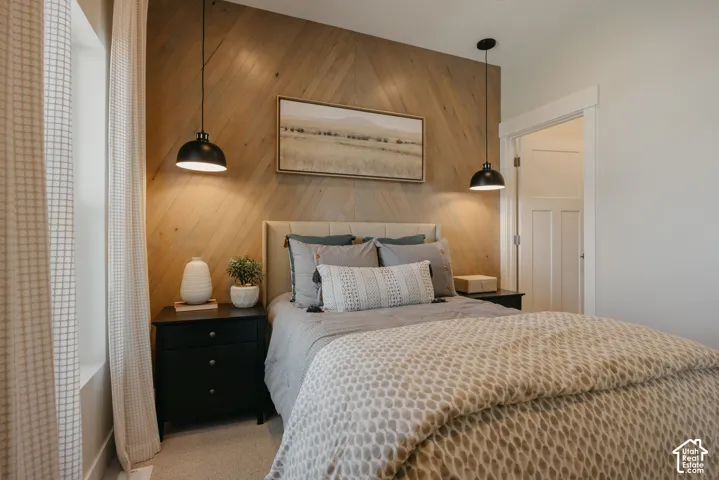 Chevron-pattern wood accent wall featuring dual matte black pendant lights and two-panel interior door