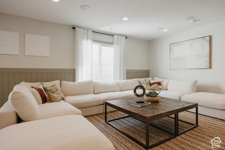 Living area featuring horizontal wainscoting, recessed lighting, and a sliding glass door