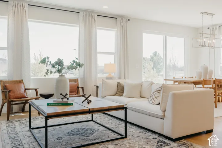 Open-concept living space featuring large windows, sliding glass door, recessed lighting, and a metal-frame chandelier