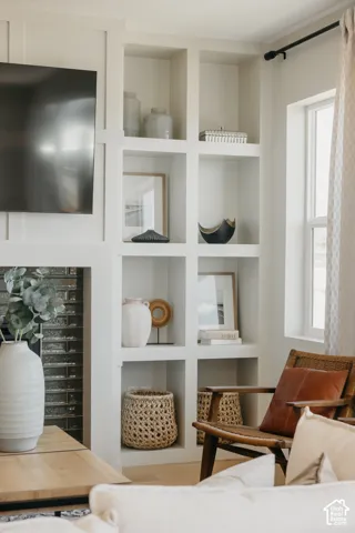 Custom built-in shelving with grid-style cabinetry surrounding a fireplace feature with horizontal dark tile surround