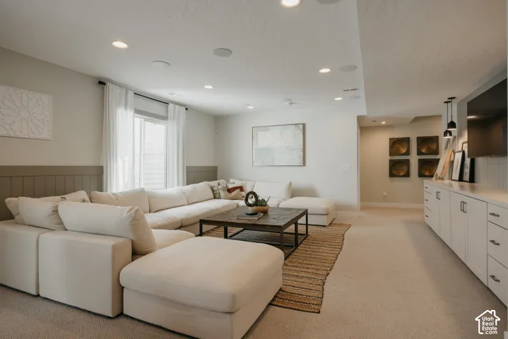Recessed lighting, custom built-in cabinetry, vertical wainscoting, and large-format window with window treatments