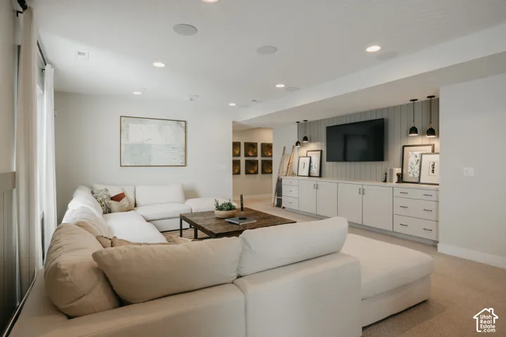 Custom built-in cabinetry featuring shaker-style drawers, recessed lighting, integrated vertical shiplap wall detail, and three pendant light fixtures