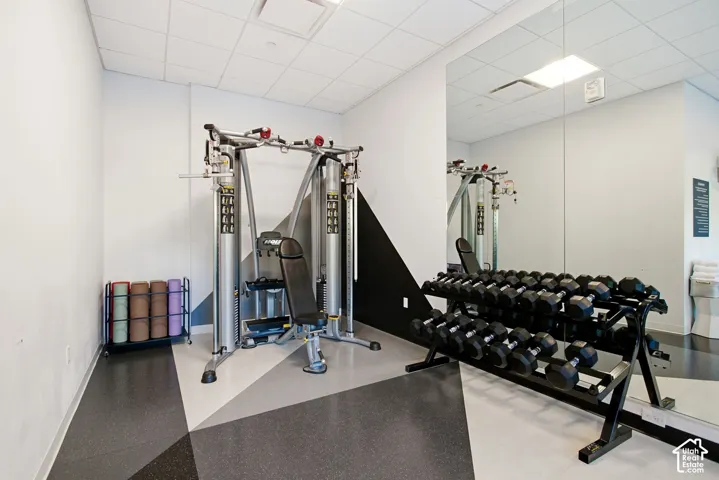 Fitness center featuring wall-to-wall mirrors, recessed lighting, and geometric-patterned flooring