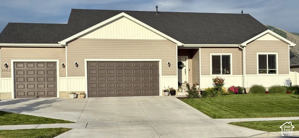 Single-story residence featuring horizontal siding, a gabled roofline, a three-car garage, and a concrete driveway