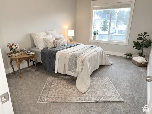 Neutral-toned walls, plush wall-to-wall carpeting, and a large sliding window with thick trim