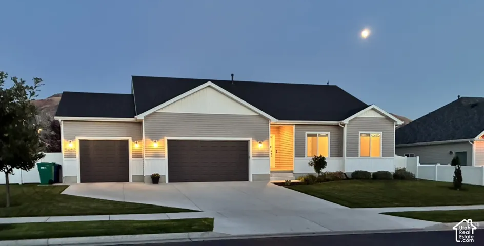 Single-level residence featuring a multi-tone siding exterior, a composite shingle roof, an attached three-car garage, and concrete driveway