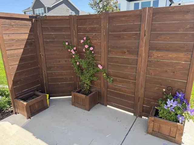 Horizontal wood-slat privacy screening featuring three integrated wood planters on a concrete patio