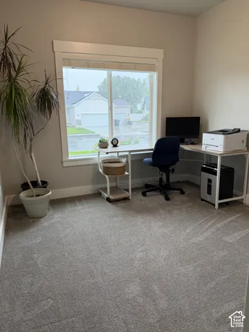 Neutral wall tones, wall-to-wall carpeting, and a wide window with thick casing trim