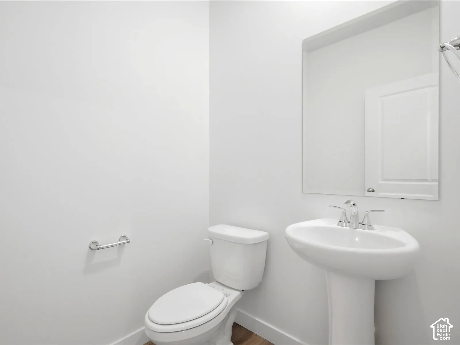 **DISCLAIMER** Interior package may vary. Pedestal sink with a polished chrome dual-handle faucet, oversized wall-mounted mirror, and white dual-flush toilet