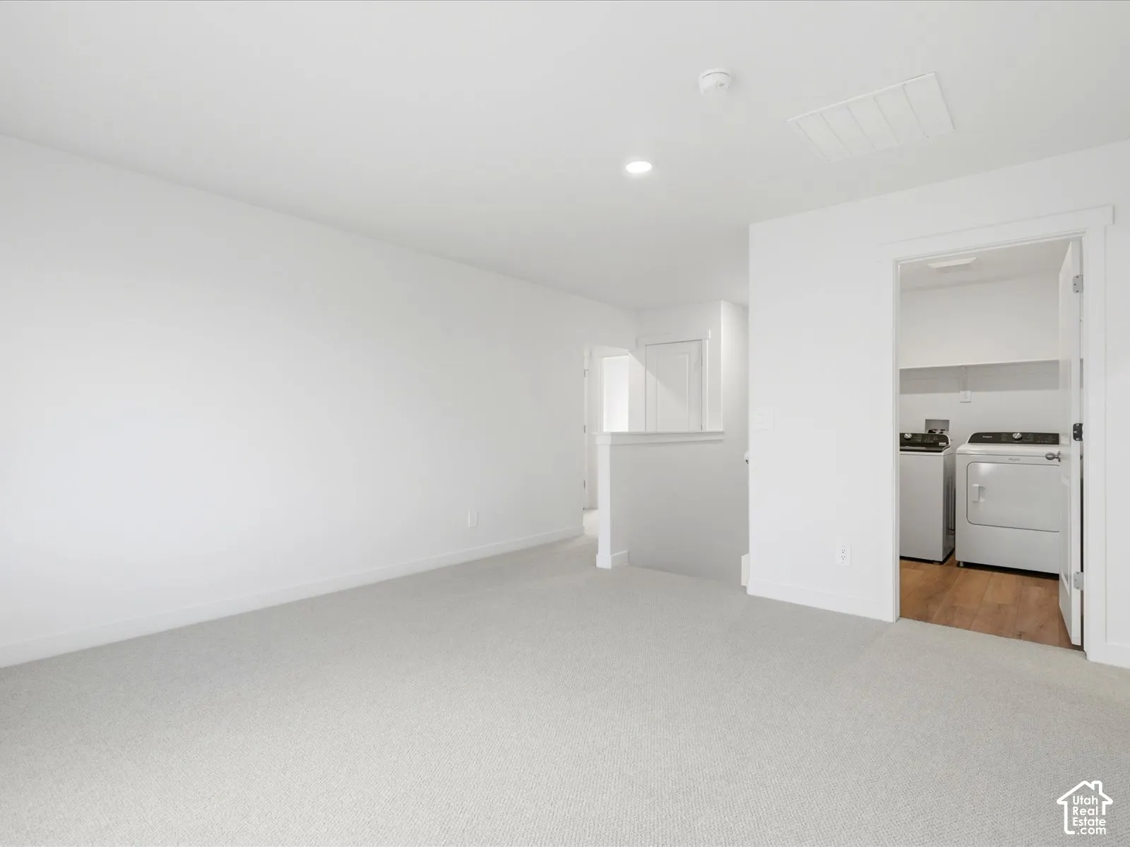 Neutral-toned wall-to-wall carpeting and recessed lighting