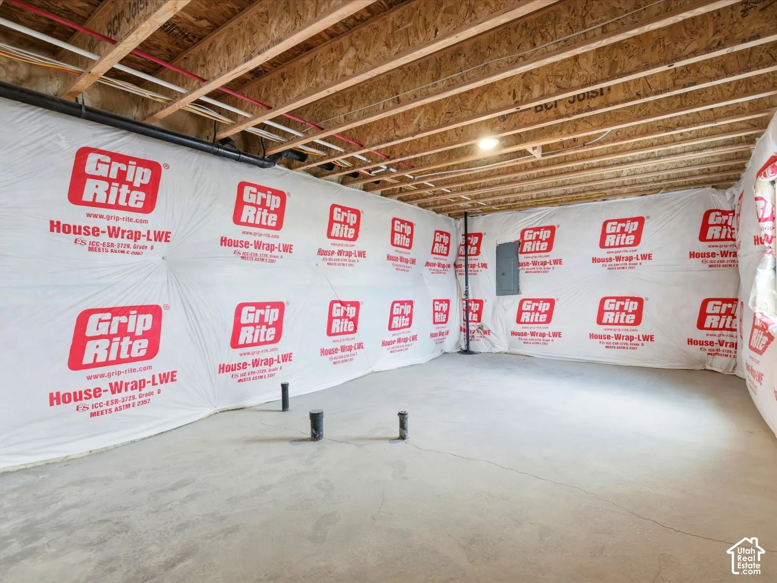 Unfinished lower level featuring exposed wood-joist ceiling, concrete flooring, and plumbing rough-ins