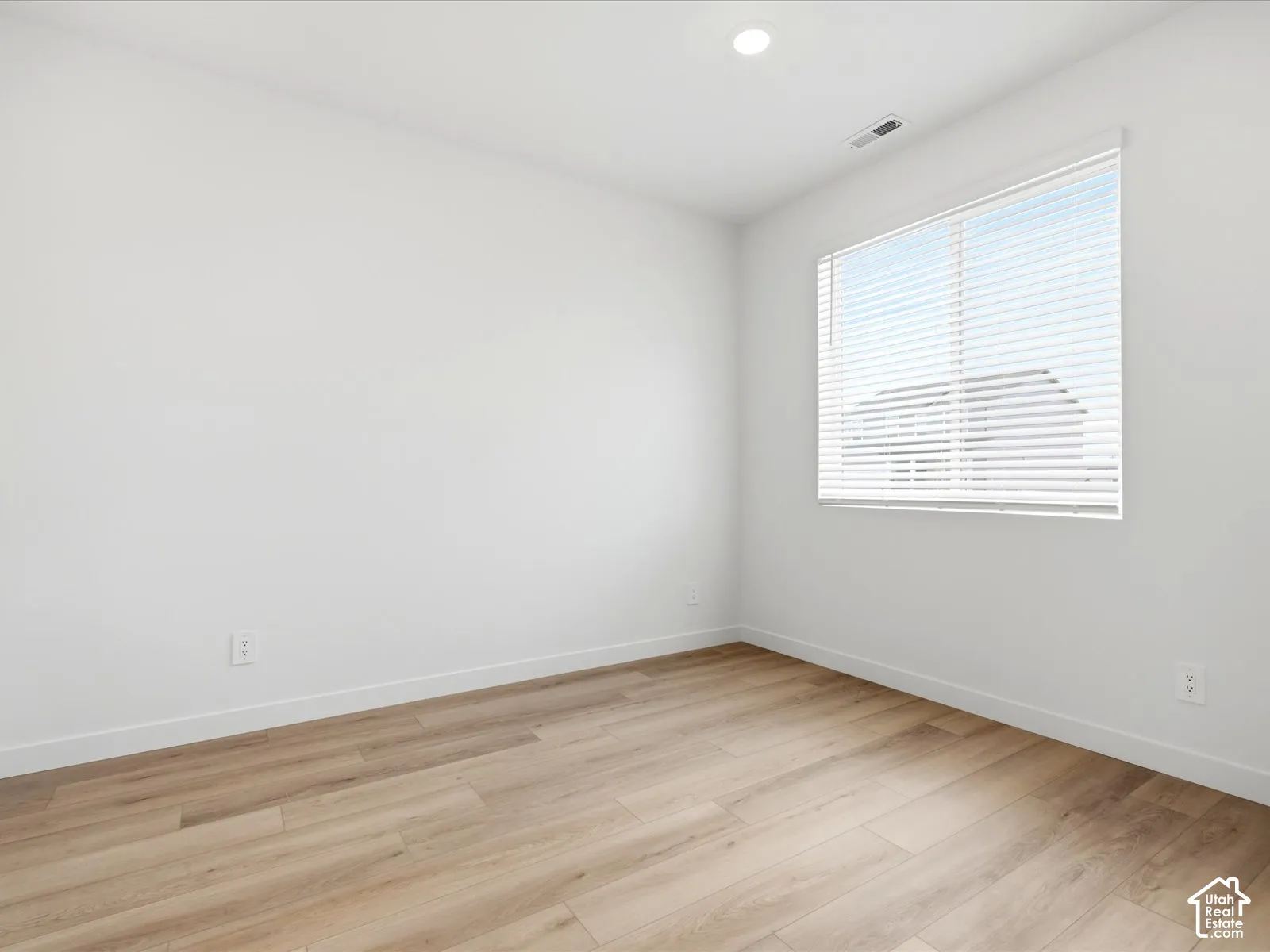 **DISCLAIMER** Interior package may vary. Neutral-toned interior room featuring wood-finish flooring, white walls, recessed ceiling lighting, and a window with horizontal blinds
