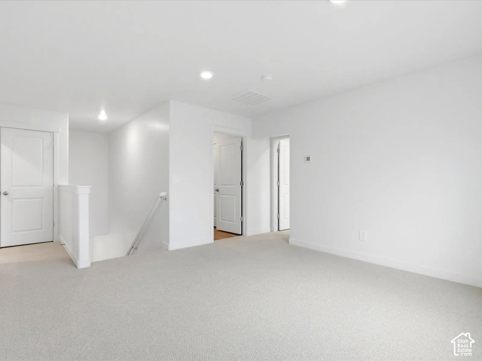 Interior space featuring neutral carpeting, recessed ceiling lighting, and solid-core interior doors