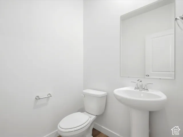 **DISCLAIMER** Interior package may vary. Pedestal sink with a polished chrome dual-handle faucet, oversized wall-mounted mirror, and white dual-flush toilet