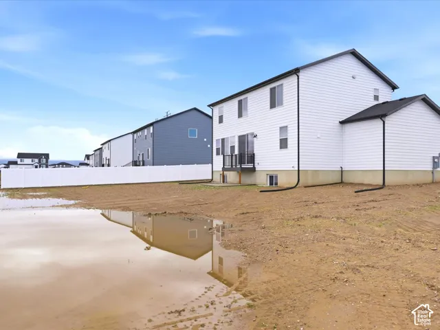 **DISCLAIMER** Fence is only for esthetic view.Two-story residence featuring white horizontal siding, a rear deck with black metal railing, concrete foundation, and a white vinyl privacy fence