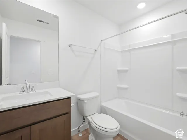 **DISCLAIMER** Interior package may vary. Bathroom featuring a vanity with a white countertop and integrated sink, recessed lighting, a full-width vanity mirror, and a shower-tub combination with integrated shelving