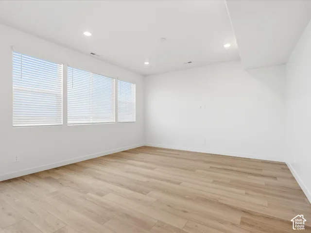 **DISCLAIMER** Interior package may vary. Interior space featuring wood-finish flooring, recessed lighting, and a wall of windows with horizontal blinds