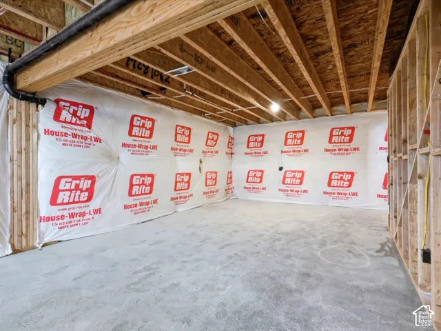 Unfinished interior space featuring exposed wood framing, an engineered support beam, and concrete flooring