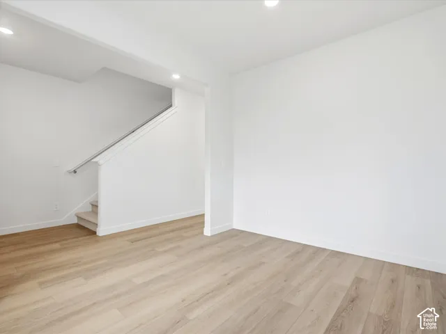 **DISCLAIMER** Interior package may vary. Neutral interior space featuring wood-finish flooring, recessed lighting, and a staircase with a white handrail
