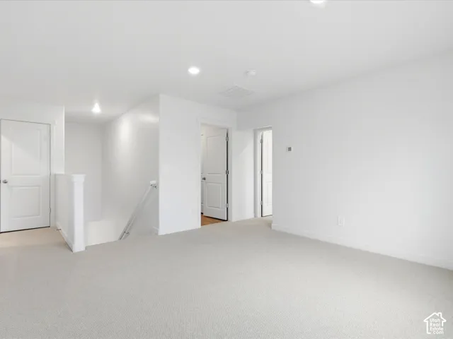 Interior space featuring neutral carpeting, recessed ceiling lighting, and solid-core interior doors