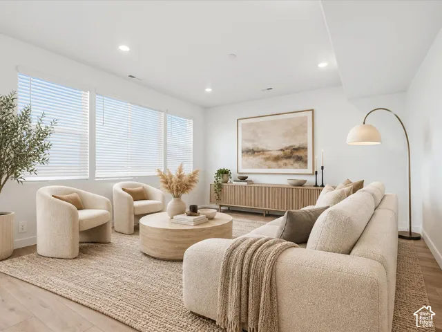 **DISCLAIMER** Interior package may vary. Living area featuring expansive windows with horizontal blinds, recessed lighting, and wood-finish flooring