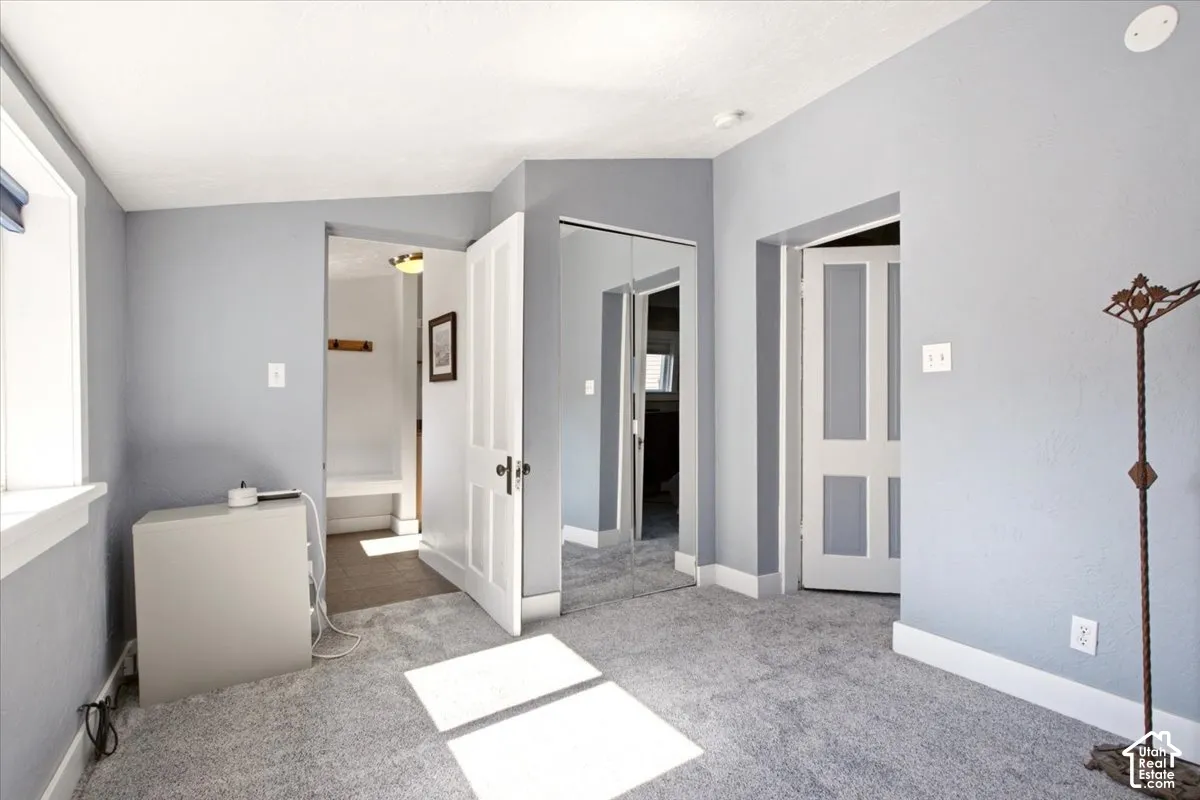 Bedroom featuring wall-to-wall carpeting, mirrored closet doors, and multi-panel interior doors