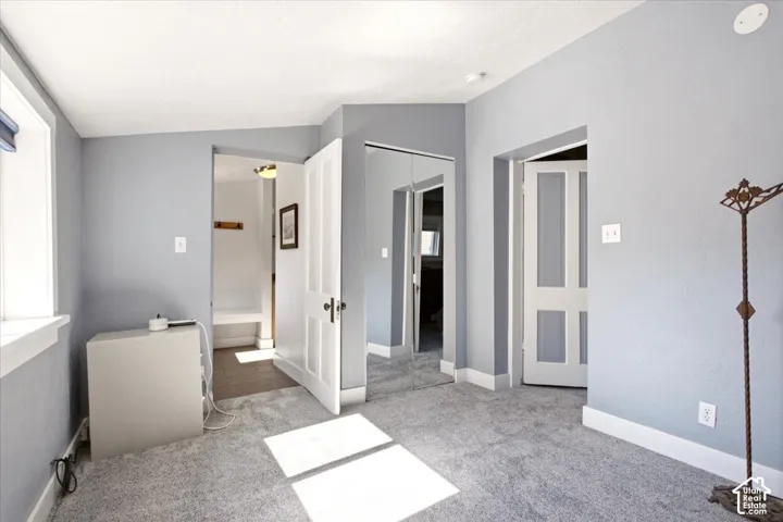 Bedroom featuring wall-to-wall carpeting, mirrored closet doors, and multi-panel interior doors