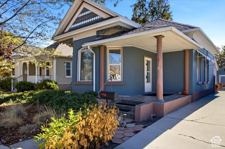 Exterior featuring decorative gable trim, covered porch with classical-style columns.