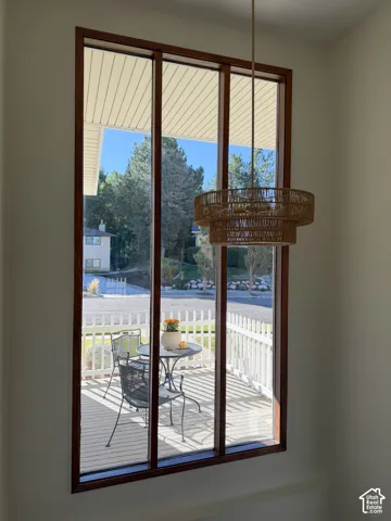 Floor-to-ceiling multi-pane window with wood trim, featuring a tiered woven pendant light fixture