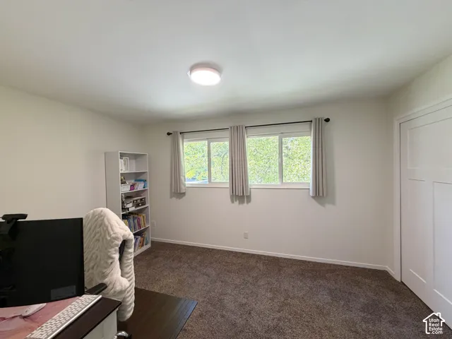 Room featuring dual sliding windows, neutral carpeting, recessed ceiling lighting, and a multi-panel door
