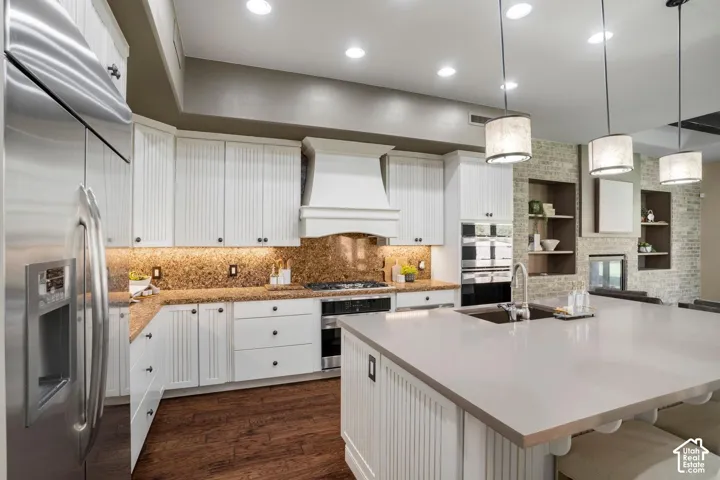 Kitchen featuring white cabinetry with beadboard detailing, quartz-topped island, stainless steel appliances, wood-finish flooring, and recessed lighting