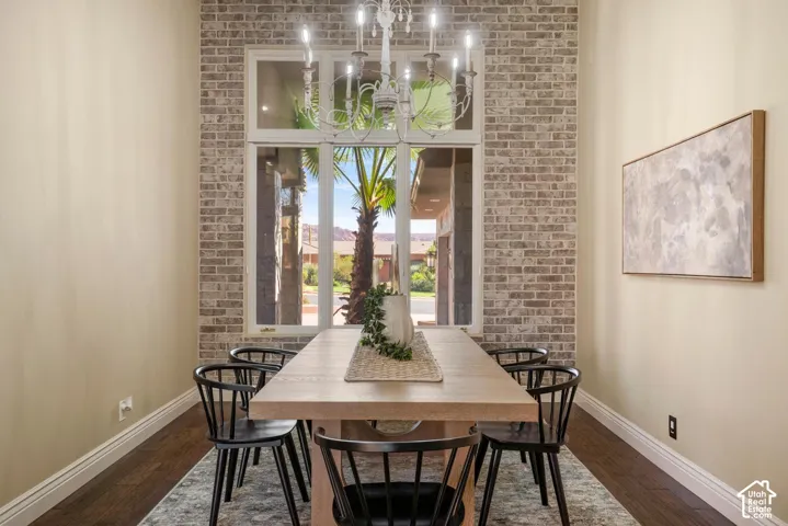 Exposed brick accent wall, multi-pane window with transom, and ornate chandelier