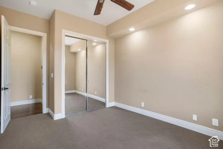 Room featuring wall-to-wall carpeting, mirrored sliding closet doors, recessed ceiling lighting, and a ceiling fan