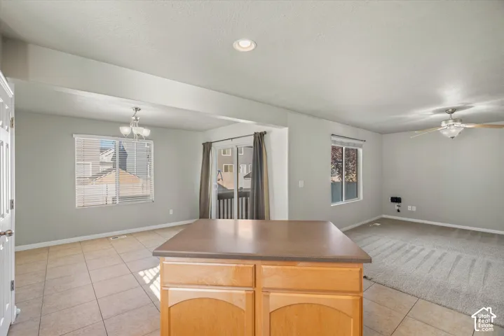 Interior featuring tile flooring, neutral wall tones, recessed lighting, a ceiling fan with integrated lighting, and sliding glass doors
