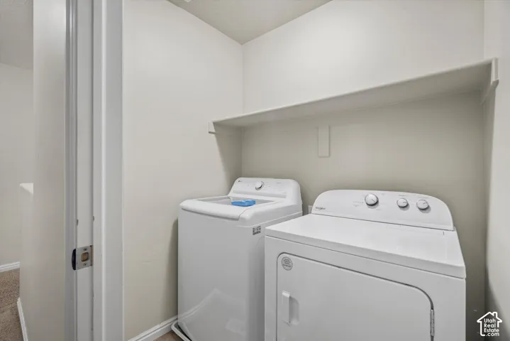 Laundry area featuring a built-in overhead storage shelf and white washer and dryer units