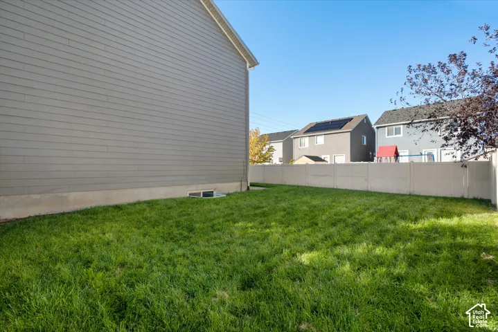 Backyard featuring horizontal siding, a level lawn, and a perimeter privacy fence