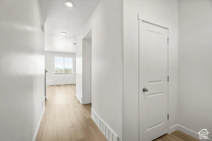 Interior space featuring wood-finish flooring, recessed lighting, and a two-panel interior door