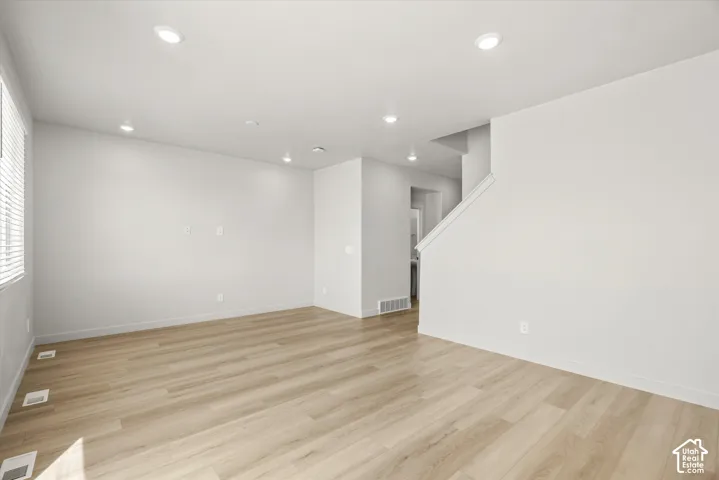 Open-concept interior featuring wood-finish flooring, recessed lighting, and white walls